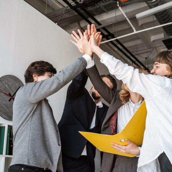 cheerful young group people standing office giving high five