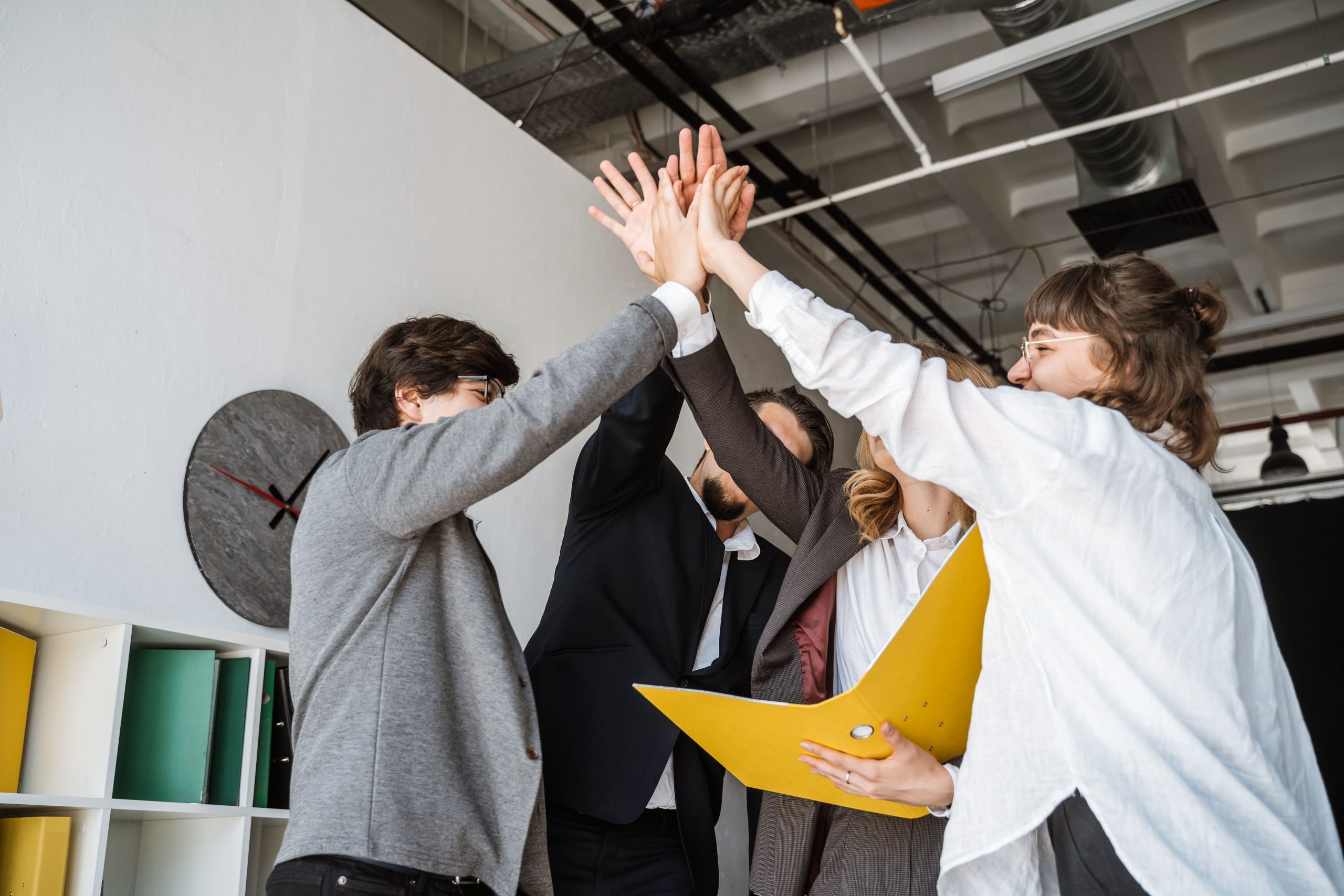 cheerful young group people standing office giving high five